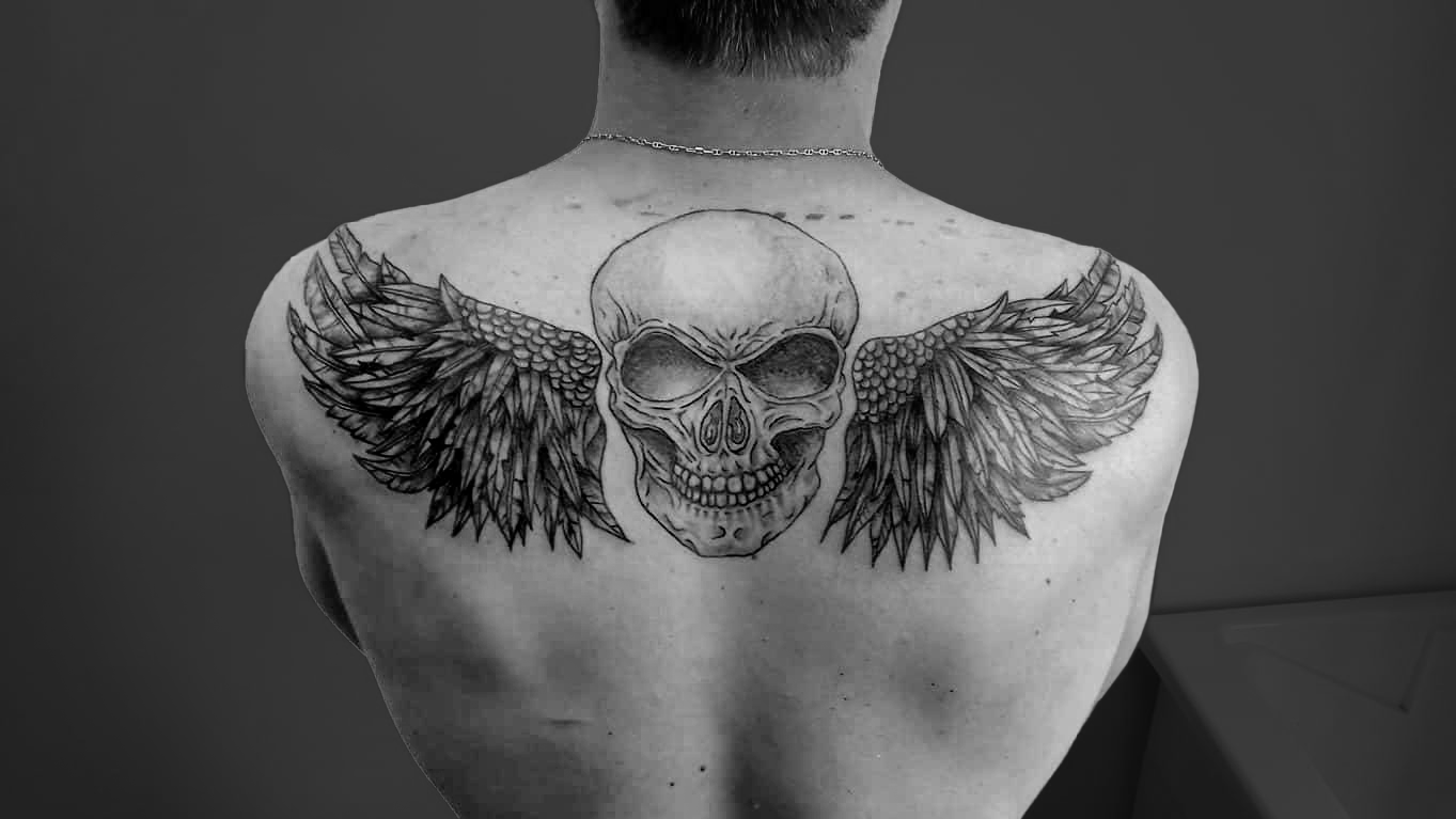 Tatouage dorsal crâne réaliste et ailes